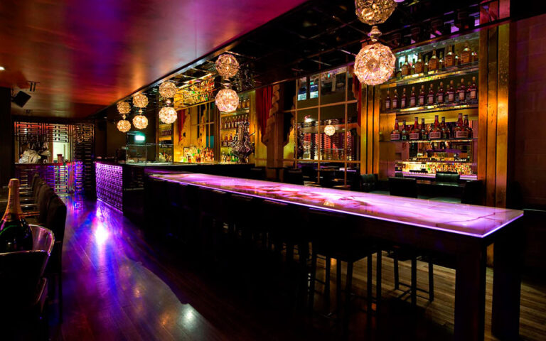 Elegant cocktail lounge interior with dim lighting, stylish seating, and a bartender preparing signature cocktails in a luxurious ambiance.