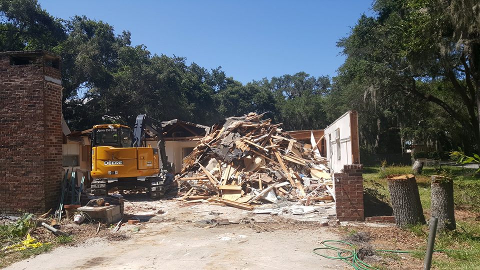 Professional debris removal services Kent WA clearing residential demolition site with heavy machinery and wood rubble cleanup.