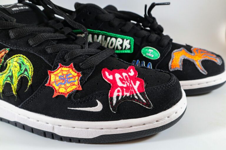 Trendy black sneakers embroidered with vibrant patches, perfect for streetwear fashion.