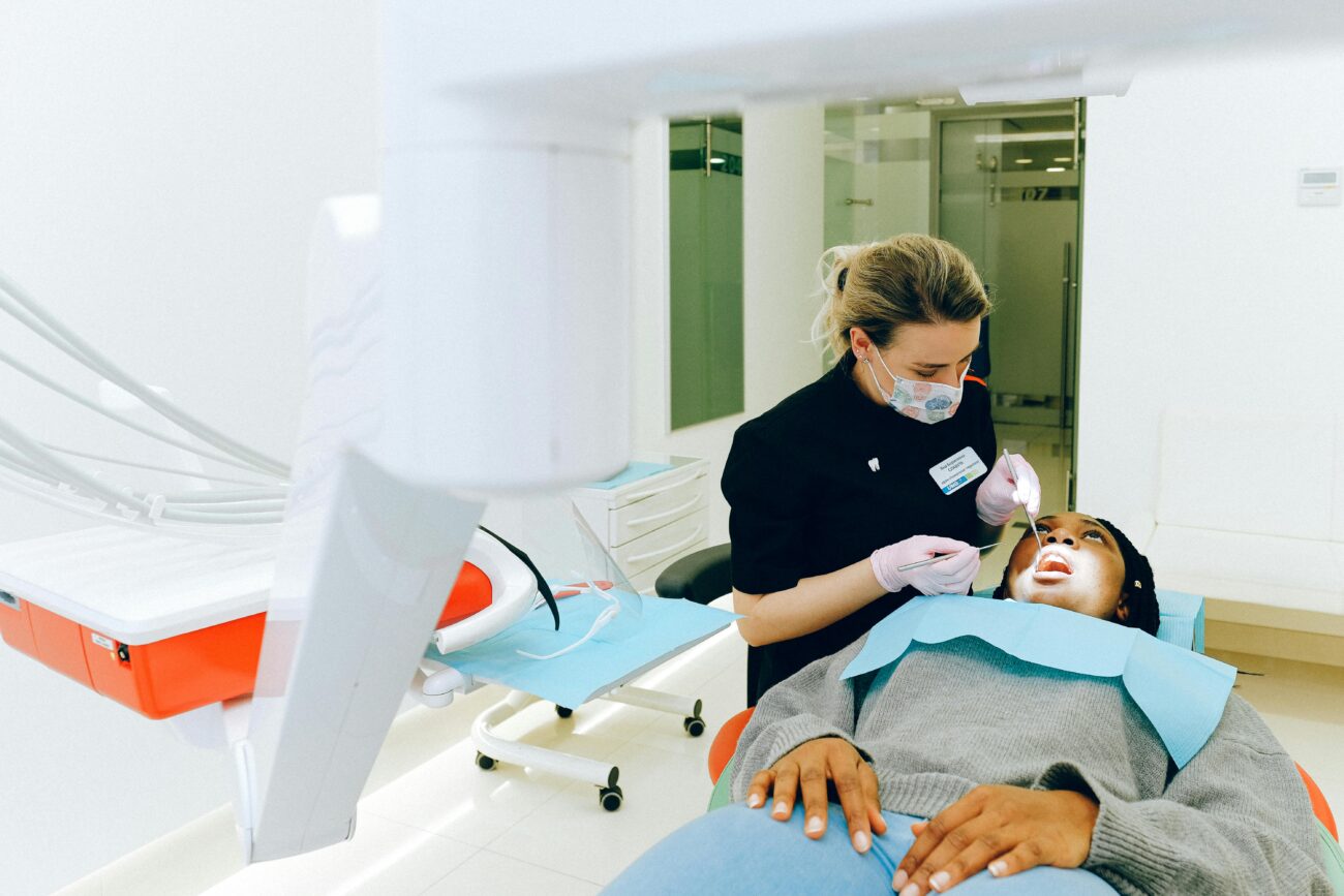 Dentist performing dental checkup on a patient in a clinic.