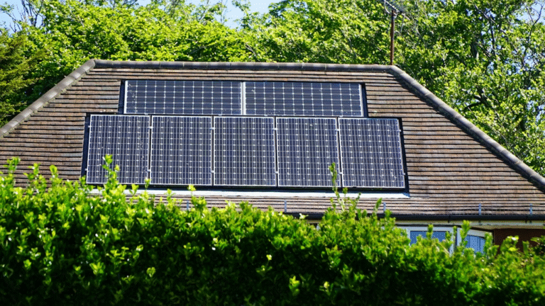Solar panels installed on a house roof partially shaded by surrounding trees
